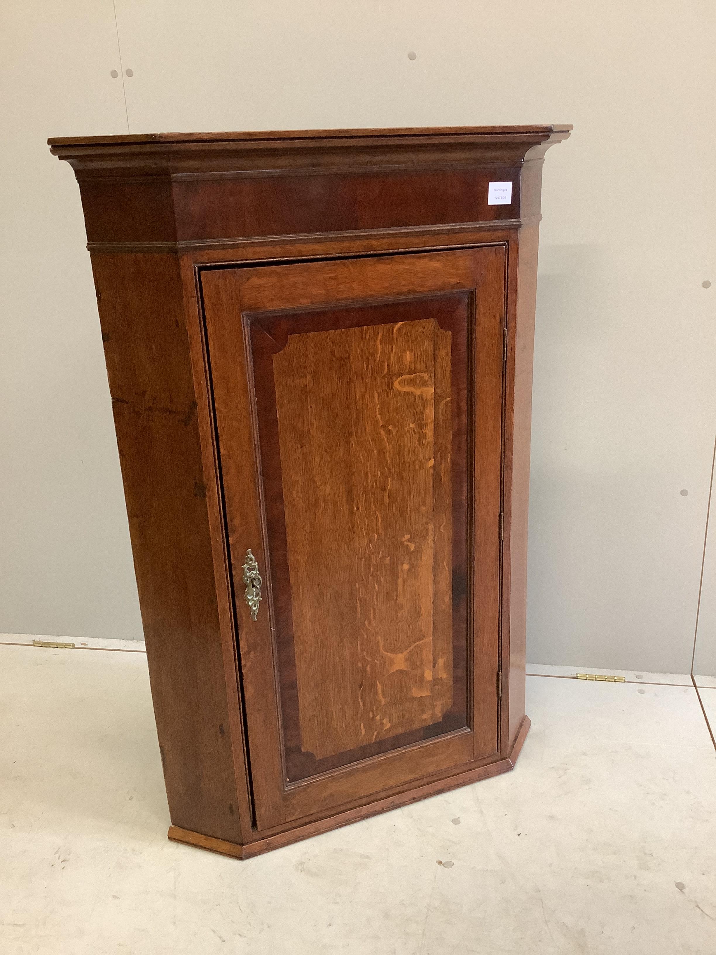 An early 19th century mahogany banded oak hanging corner cupboard, width 81cm, depth 48cm, height 119cm
